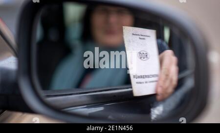 Magdebourg, Allemagne. 31 décembre 2020. Une femme détient un permis de conduire de la RDA dans sa main. Les permis de conduire de la RDA sont encore valables dans la 31e année de l'unification allemande. Toutefois, ils doivent être échangés graduellement, échelonnés selon les cohortes de naissance. Les derniers permis de conduire de la RDA perdront leur validité en janvier 2033. Credit: Stephan Schulz/dpa-Zentralbild/ZB/dpa/Alay Live News Banque D'Images
