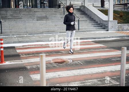 Une personne qui fait du jogging traverse une traversée Banque D'Images