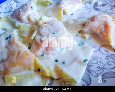 assiette de pâtes aux œufs, raviolis, farcie de garniture de citrouille et de saucisse, assaisonnée de beurre et de sauge, pour le déjeuner de fête Banque D'Images