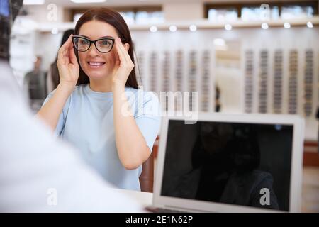 Femme pressant de grands verres à ses yeux Banque D'Images