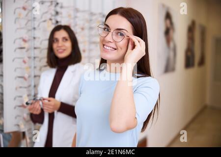 Une femme se déplace des lunettes sur son visage dans une meilleure position Banque D'Images