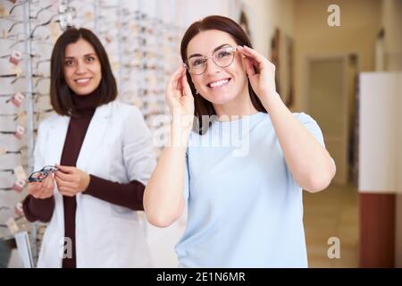 Une femme ravie de mettre des lunettes avec un professionnel de la santé Banque D'Images