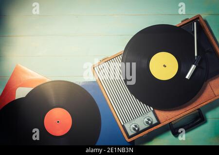 Gramophone vintage des années 70 avec des disques en vinyle sur table en bois vert, vue du dessus et espace de copie. Banque D'Images