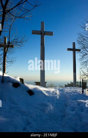Trois croix gigantesques placées au sommet d'une montagne, immergées dans la neige de janvier, en arrière-plan un ciel bleu intense Banque D'Images
