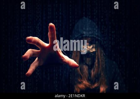 Jeune femme hacker avec masque de visage sur un écran avec code binaire Banque D'Images