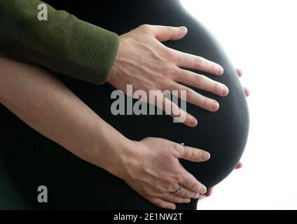 Femmes enceintes avec partenaire tenant sur la bosse. Banque D'Images