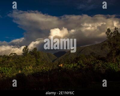 Des nuages denses couvrent les montagnes andines centrales de Colombie près de certaines terres agricoles au coucher du soleil. Banque D'Images