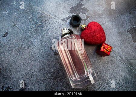 bouteille de parfum et coeurs sur fond gris, un cadeau pour la saint-valentin Banque D'Images