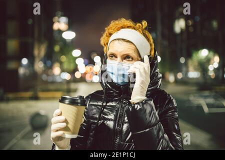 Vie urbaine européenne due à la réglementation de quarantaine pendant la pandémie de covid19. La femme adulte résidant dans la ville observe les mesures de sécurité, porte des masques et du verre Banque D'Images