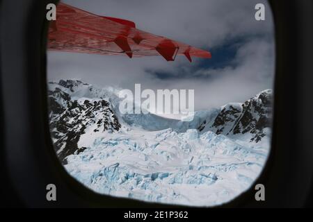 Vue aérienne de la glace depuis le glacier à travers la fenêtre de l'avion avec aile Banque D'Images