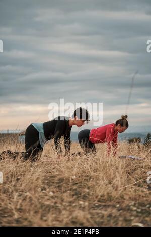 Groupe de femmes pratiquant le Pilates à la campagne Banque D'Images