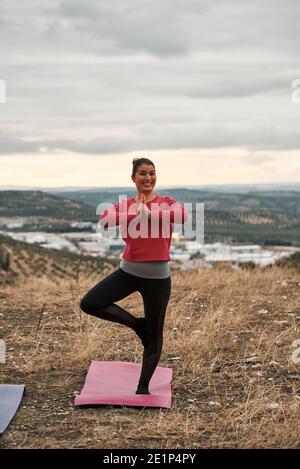 Une jeune femme pratique Pilates au coucher du soleil Banque D'Images