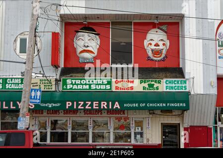 Des visages tristes et heureux décorent les murs extérieurs d'une arcade classique et d'un restaurant sur la promenade à Salisbury Beach, Massachusetts sur un plus Banque D'Images