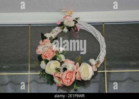 Couronne de mariage sur la porte. Couronne de roses roses roses et blanches, composition fleurs roses forme un cadre naturel sur la porte. Le présidium de mariage Banque D'Images