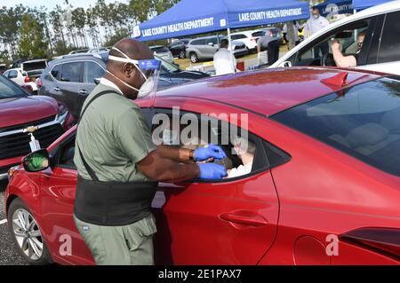 Clermont, États-Unis. 08 janvier 2021. Un travailleur de la santé donne à une femme une dose du vaccin Pfizer COVID-19 lors d'un événement de vaccination au drive parrainé par le département de santé du comté de Lake pour les personnes de 65 ans et plus au centre des arts et loisirs de Clermont. Les résidents ont attendu jusqu'à trois heures lors du premier événement de distribution de vaccins arrivé et servi, tandis que les nouveaux cas quotidiens de coronavirus en Floride sont actuellement à des niveaux records. Crédit : SOPA Images Limited/Alamy Live News Banque D'Images