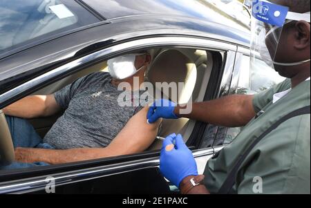 Clermont, États-Unis. 08 janvier 2021. Un travailleur de la santé donne à un homme une dose du vaccin Pfizer COVID-19 lors d'un événement de vaccination au drive parrainé par le département de santé du comté de Lake pour les personnes de 65 ans et plus au centre des arts et loisirs de Clermont. Les résidents ont attendu jusqu'à trois heures lors du premier événement de distribution de vaccins arrivé et servi, tandis que les nouveaux cas quotidiens de coronavirus en Floride sont actuellement à des niveaux records. Crédit : SOPA Images Limited/Alamy Live News Banque D'Images