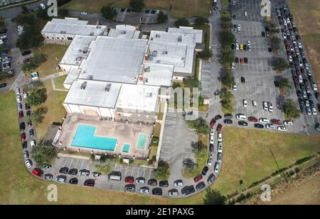 Clermont, États-Unis. 08 janvier 2021. (NOTE DE LA RÉDACTION : image prise avec un drone) des centaines de voitures s'alignent alors que les gens attendent de recevoir une dose du vaccin Pfizer COVID-19 lors d'un événement de vaccination au volant parrainé par le département de santé du comté de Lake pour les personnes de 65 ans et plus au centre des arts et loisirs de Clermont. Les résidents ont attendu jusqu'à trois heures lors du premier événement de distribution de vaccins arrivé et servi, tandis que les nouveaux cas quotidiens de coronavirus en Floride sont actuellement à des niveaux records. Crédit : SOPA Images Limited/Alamy Live News Banque D'Images