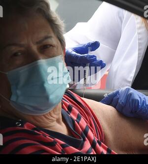 Clermont, États-Unis. 08 janvier 2021. Un travailleur de la santé donne à une femme une dose du vaccin Pfizer COVID-19 lors d'un événement de vaccination au drive parrainé par le département de santé du comté de Lake pour les personnes de 65 ans et plus au centre des arts et loisirs de Clermont. Les résidents ont attendu jusqu'à trois heures lors du premier événement de distribution de vaccins arrivé et servi, tandis que les nouveaux cas quotidiens de coronavirus en Floride sont actuellement à des niveaux records. Crédit : SOPA Images Limited/Alamy Live News Banque D'Images