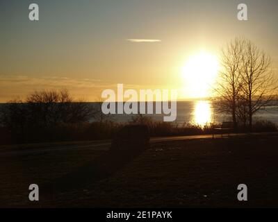 Ajax Ontario hommage au HMS Ajax River plate Battle. Coucher de soleil par le lac avec des arbres et une rive lointaine. Banque D'Images