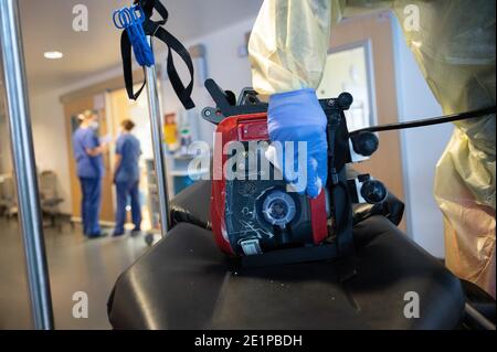 Ludwigsburg, Allemagne. 08 janvier 2021. Un homme nettoie une partie d'une civière de soins intensifs dans une unité de soins intensifs du RKH Klinikum Ludwigsburg, où un patient vient d'être livré d'un autre hôpital. Dans le Bade-Wurtemberg, l'occupation des unités de soins intensifs est gérée à l'aide d'un concept de cluster. Les patients en soins intensifs peuvent être transférés entre les hôpitaux des six zones de service afin d'obtenir une meilleure répartition entre les hôpitaux. Credit: Sebastian Gollnow/dpa/Alay Live News Banque D'Images