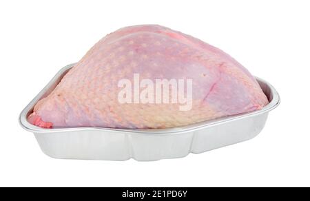 Viande de couronne de dinde entière crue dans un plat à rôtir isolé sur un fond blanc Banque D'Images
