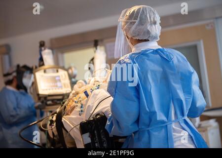 Ludwigsburg, Allemagne. 08 janvier 2021. L'équipe d'un véhicule de transport de soins intensifs conduit un patient qui a été transféré d'un autre hôpital sur une civière de soins intensifs dans une unité de soins intensifs du RKH Klinikum Ludwigsburg. Dans le Bade-Wurtemberg, l'occupation des unités de soins intensifs est contrôlée à l'aide d'un concept de cluster. Les patients en soins intensifs peuvent être transférés entre les hôpitaux des six zones de service afin d'obtenir une meilleure répartition entre les hôpitaux. Credit: Sebastian Gollnow/dpa/Alay Live News Banque D'Images