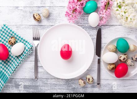 Réglage de la table à ressort. Assiette de menthe blanche, œufs de pâques, jacinthe et couverts argentés sur fond de bois. Copier l'espace. Vue de dessus - image Banque D'Images