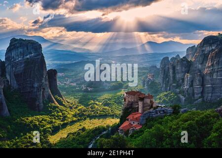 Vue sur le coucher du soleil de la nunnery de Moni Agias Varvaras Roussanou et des rochers de Meteora, Grèce et vallée. Ciel nuageux, rayons du soleil. Patrimoine mondial de l'UNESCO Banque D'Images