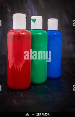 Trois bouteilles de peinture acrylique dans l'ordre rouge, vert, bleu, les couleurs primaires de l'espace colorimétrique RVB additif Banque D'Images