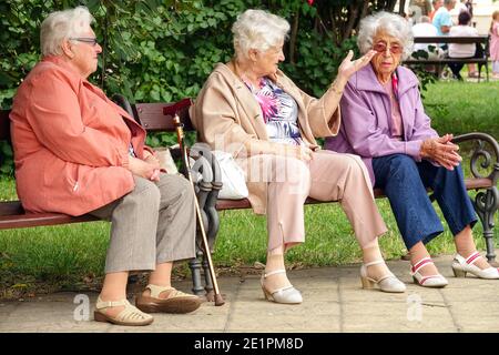 Trois femmes âgées assises sur le banc dans le parc municipal Seniors Ageing, Old Women banc les personnes âgées parlant personnes âgées population vieillissante amis seniors à l'extérieur Banque D'Images