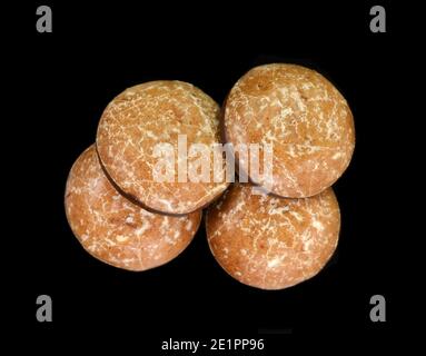 Lebkuchens de pain d'épice glacé au chocolat isolé sur noir. Pain d'épice rond allemand appelé « Lebkuchen » Banque D'Images