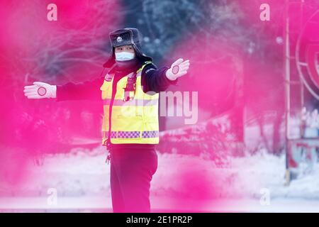 Dahinggan, province chinoise de Heilongjiang. 8 janvier 2021. Le policier Sun Chen dirige la circulation à un carrefour dans le district de Huzhong à Dahinggan, dans la province de Heilongjiang, au nord-est de la Chine, le 8 janvier 2021. Sun Chen a servi comme policier de la circulation pendant 35 ans. Dans le district de Huzhong, surnommé « la ville la plus froide de Chine », Sun a collé à son poste pour maintenir l'ordre de circulation. Il a pris son quart tôt le matin, en dépit du temps extrêmement froid avec la température la plus basse atteignant environ moins 40 degrés Celsius. Crédit : Wang Jianwei/Xinhua/Alay Live News Banque D'Images