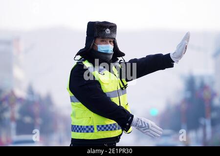 Dahinggan, province chinoise de Heilongjiang. 8 janvier 2021. Le policier Sun Chen dirige la circulation à un carrefour dans le district de Huzhong à Dahinggan, dans la province de Heilongjiang, au nord-est de la Chine, le 8 janvier 2021. Sun Chen a servi comme policier de la circulation pendant 35 ans. Dans le district de Huzhong, surnommé « la ville la plus froide de Chine », Sun a collé à son poste pour maintenir l'ordre de circulation. Il a pris son quart tôt le matin, en dépit du temps extrêmement froid avec la température la plus basse atteignant environ moins 40 degrés Celsius. Crédit : Wang Jianwei/Xinhua/Alay Live News Banque D'Images