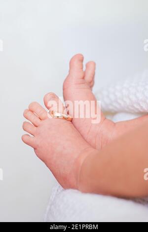 Anneau de mariage sur le pouce des jambes des petits enfants arrière-plan blanc Banque D'Images