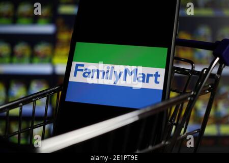 Viersen, Allemagne - mai 9. 2020: Gros plan de l'écran de téléphone mobile dans le modèle de panier avec le logo lettrage de la chaîne japonaise de supermarchés familymart Banque D'Images