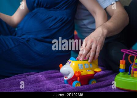 Une femme enceinte vêtue d'une robe bleue est assise avec son mari Banque D'Images