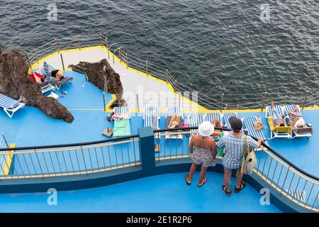 Hôtel avec des personnes en chaise de plage sur la côte de l'île de Madère Banque D'Images