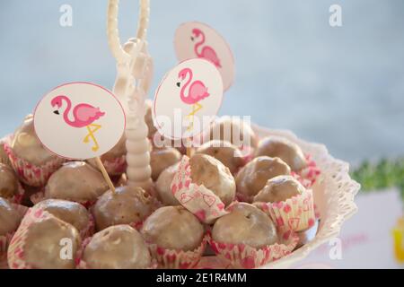 Gros plan de bonbons faits maison avec des bâtons de flamants roses sur un présentoir à gâteaux, concept de fête, bonbons pour la fête d'anniversaire Banque D'Images