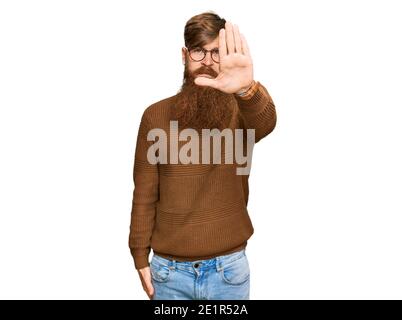 Jeune irlandais redhead homme portant des vêtements décontractés et des lunettes faisant cesser de chanter avec la paume de la main. Avertissement expression avec un geste négatif et sérieux Banque D'Images