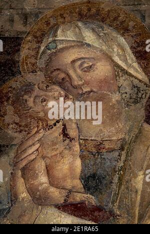 Vierge et enfant. Fresque médiévale, probablement peinte en 1300s par un peintre de l'école sienaise. Dans la Chiesa di Sant’Alessandro, à Volterra, Toscane, Italie. La fresque, aujourd'hui connue sous le nom de Madonna del Cavallaro, aurait été découverte par un cheval en 1700s. Banque D'Images