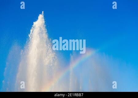 Couleurs arc-en-ciel et ciel bleu dans la fontaine de Schwarzenbergplatz à Vienne, Autriche. Banque D'Images