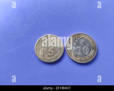 Monnaie indienne pièces de roupies cinq et dix avec neuf le design et le motif sont conservés sur un plan de gros plan bleu Banque D'Images