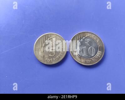 Monnaie indienne pièces de roupies cinq et dix avec neuf le design et le motif sont conservés sur un plan de gros plan bleu Banque D'Images