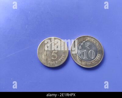Monnaie indienne pièces de roupies cinq et dix avec neuf le design et le motif sont conservés sur un plan de gros plan bleu Banque D'Images