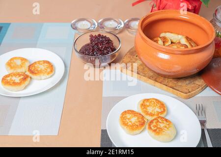 Crêpes au fromage cottage dans une assiette et un pot d'argile, avec confiture sur une table de serveurs délicieux dessert au fromage cottage. Photo de haute qualité Banque D'Images