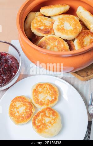 Crêpes au fromage cottage dans une assiette et un pot d'argile, avec confiture sur une table de serveurs délicieux dessert au fromage cottage. Photo de haute qualité Banque D'Images