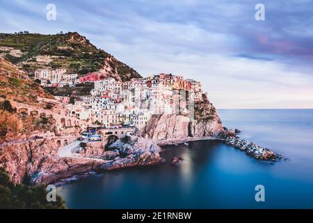 ITALIE, COUCHER DE SOLEIL À MANAROLA: Manarola, hameau de Riomaggiore, est un joyau de l'urbanisme, riche comme il est dans les maisons typiques de la tour de style génovois. Fondé au XIIe siècle, le village tire probablement son nom d'une ancienne 'magna roea', une grande roue de moulin présente dans le village. Banque D'Images