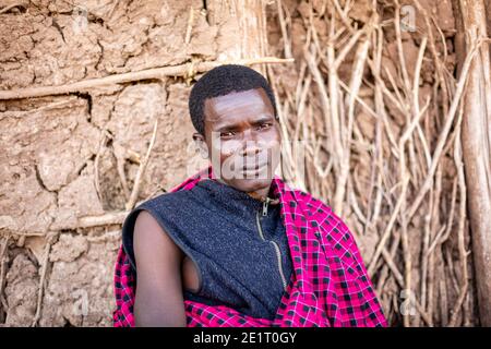 jeune guerrier de datoga dans ses vêtements traditionnels assis à l'extérieur de son maison Banque D'Images