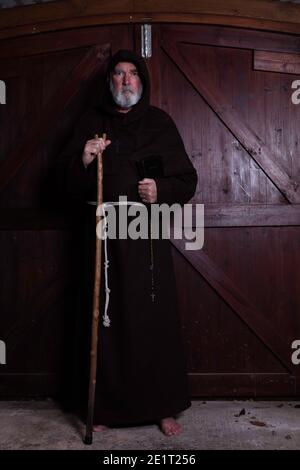 Moine franciscain, appâté, avec sa bible et son personnel. Banque D'Images