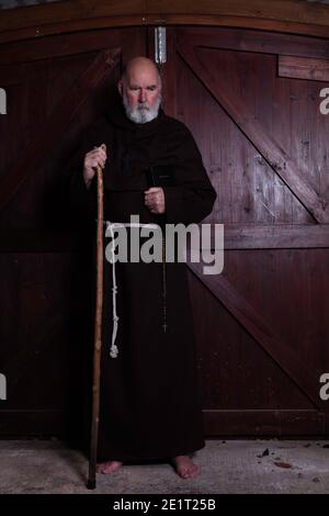 Moine franciscain, appâté, avec sa bible et son personnel. Banque D'Images